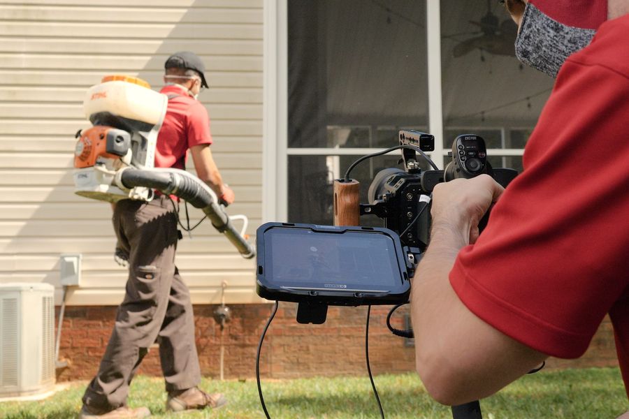 A Go-Forth technician treating the foundation of a home with a backpack sprayer