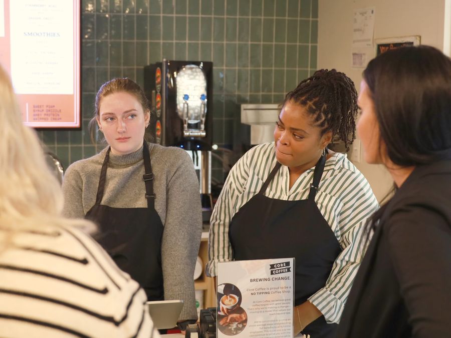 Core Coffee baristas in aprons serving guests at the counter